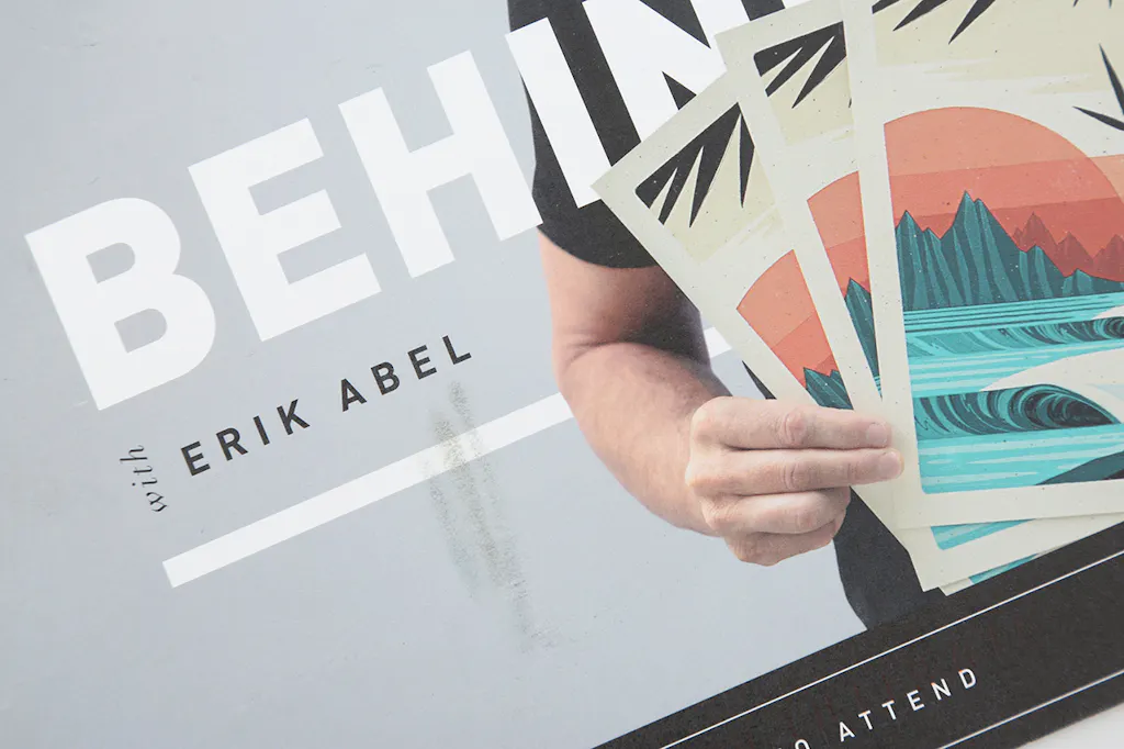 A marketing postcard printed with a man holding posters and Behind the Print With Erik Abel. 