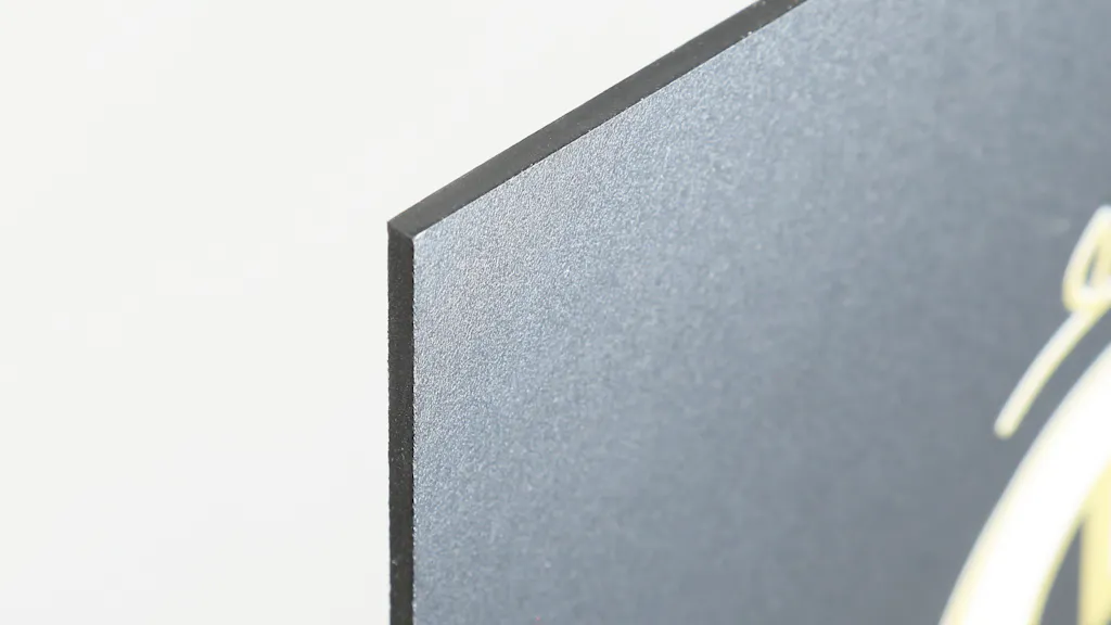 The corner of a custom PVC sign with a black design.