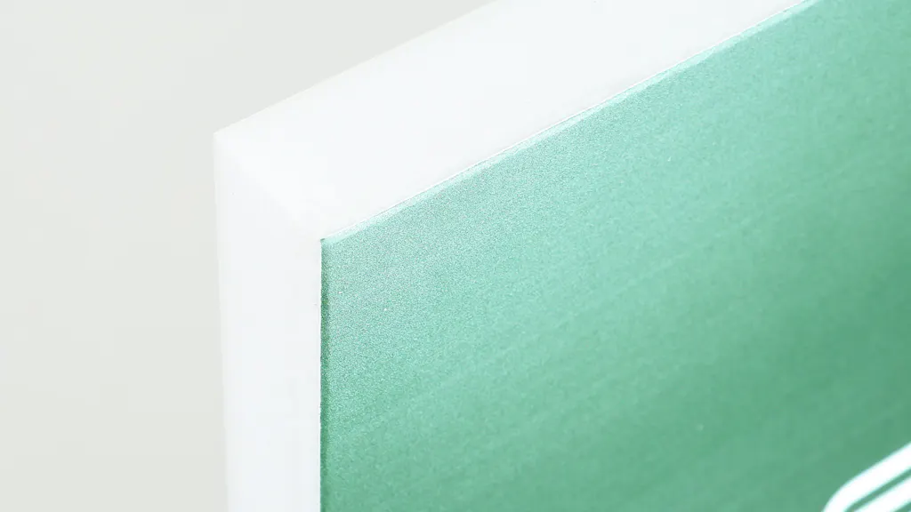 The corner of a custom polystyrene sign printed with a green design.