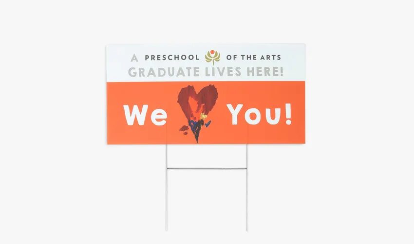 A custom yard sign printed with A Preschool of the Arts Graduate Lives Here in orange and white.