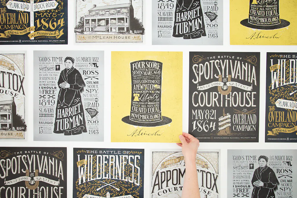 Custom posters lined up in rows with historical dates and designs with a hand holding the poster in the middle.