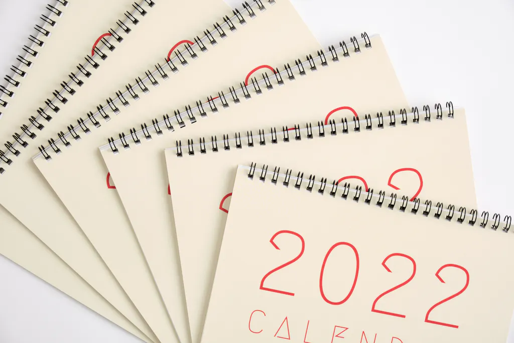 Six wire bound calendars fanned out and overlapping each other with black wire bindings and 2022 on the covers.