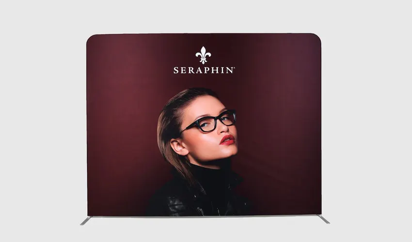 A tension fabric display printed with a dark red background, a woman wearing glasses and Seraphin in white. 