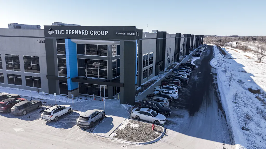 The outside of a gray and blue building with The Bernard Group and Smartpress on the top.