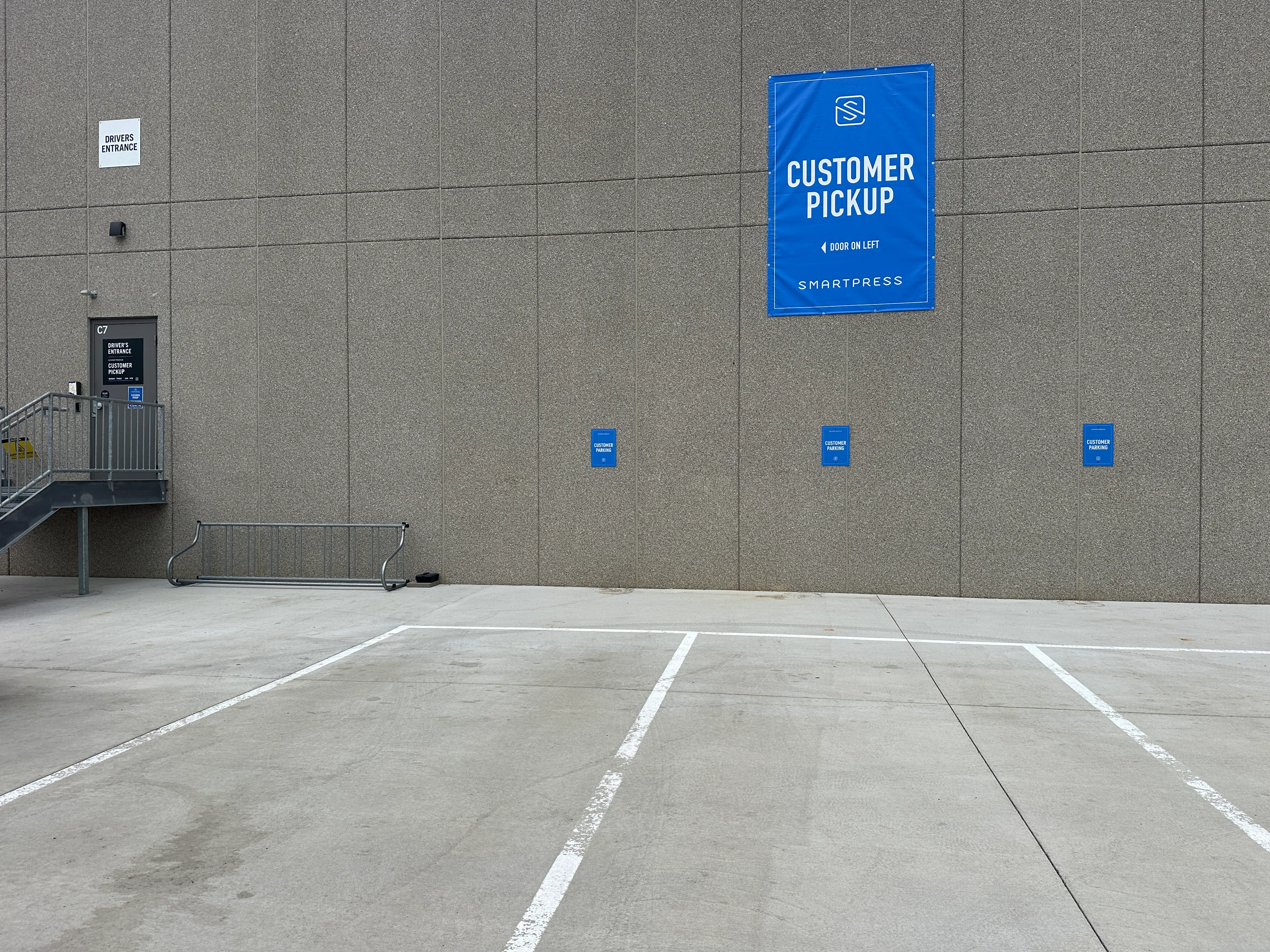 The customer pickup area at Smartpress, with blue signage on the building and door.