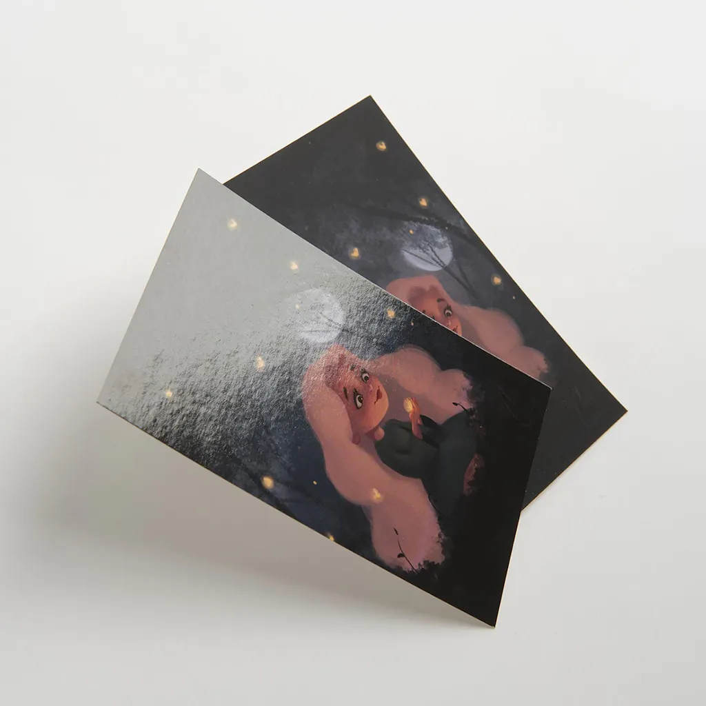 A custom postcard printed with a gloss finish overlapping another postcard with a matte finish.