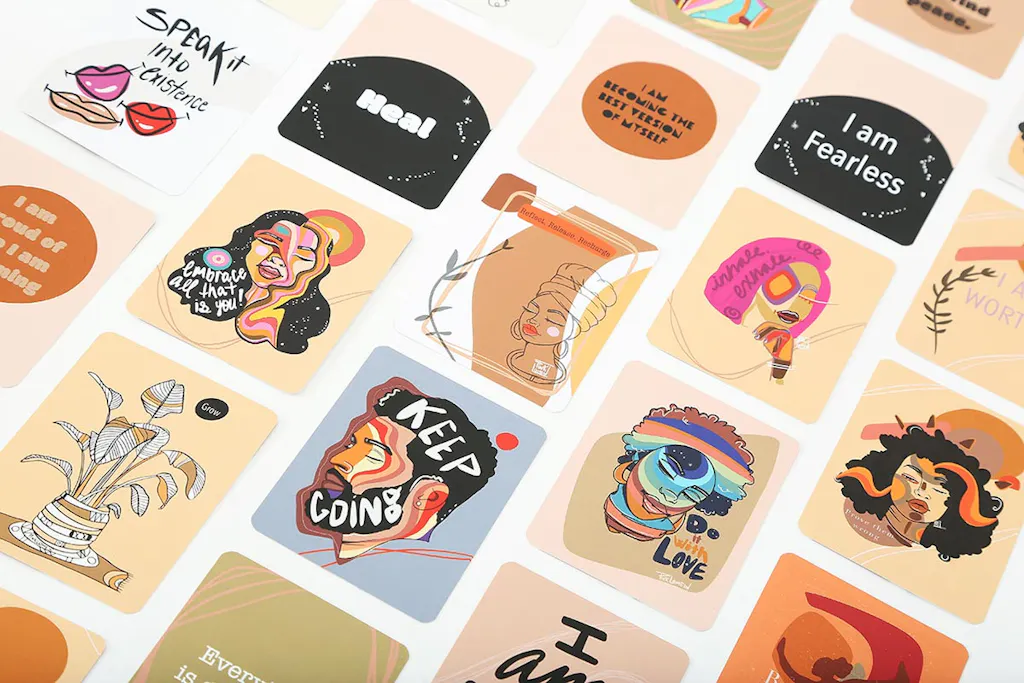 A motivational card deck laid out in rows with custom illustrations and encouraging phrases.