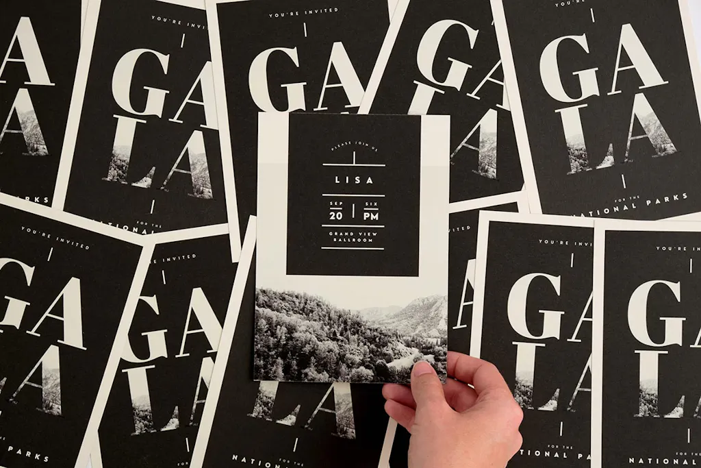 A collage of overlapping custom invitations for a gala with a hand holding the one in the middle.