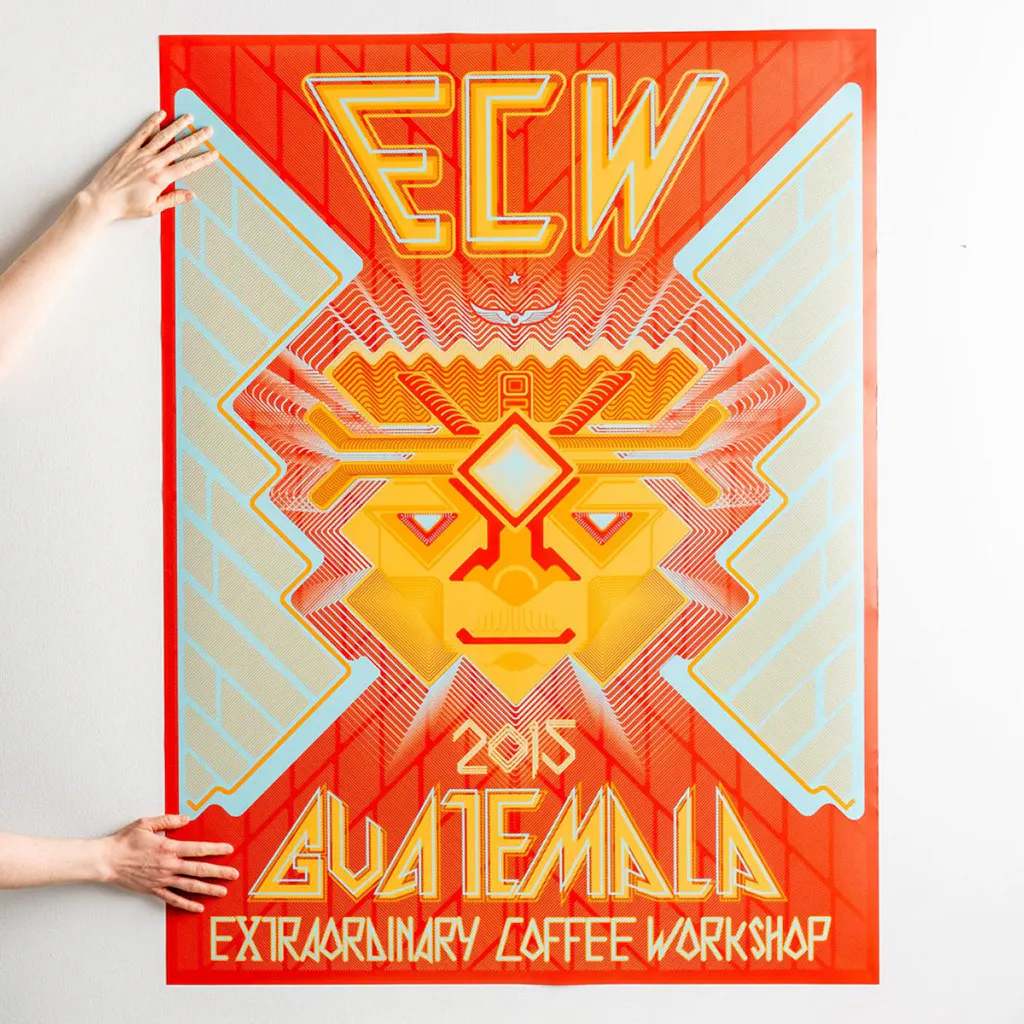 Two hands holding a large poster with 2015 Guatemala Extraordinary Coffee Worship and an orange and gold design.