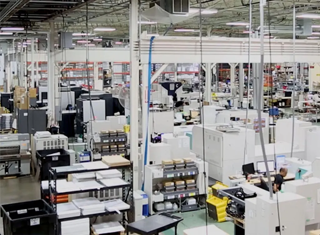 The production floor of a printing company with various print presses and printing supplies.