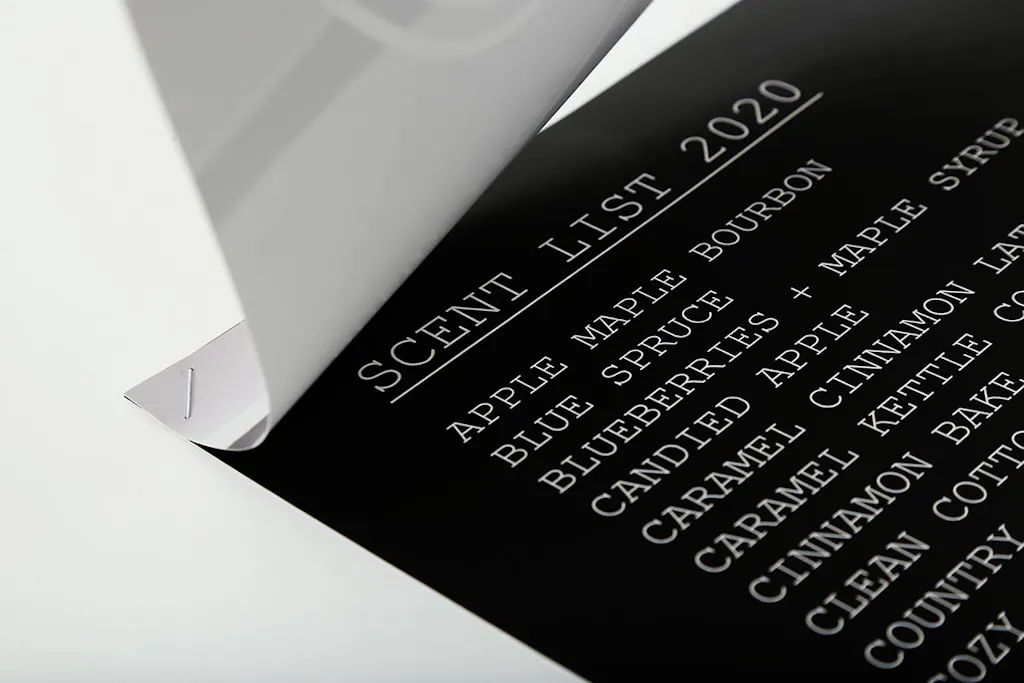 Two custom flyers stapled together with the top flyer folded over and a scent list printed on the bottom flyer.