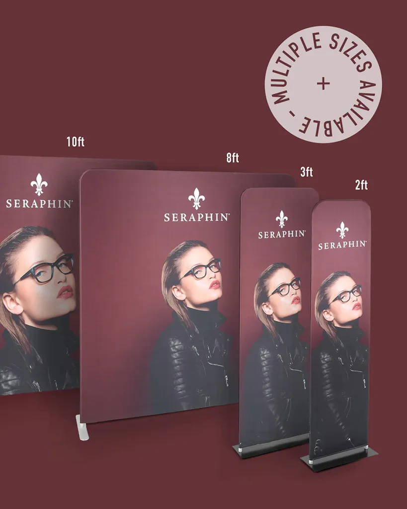 Four tension fabric displays in various sizes lined up in a row with a woman in glasses and a maroon background.