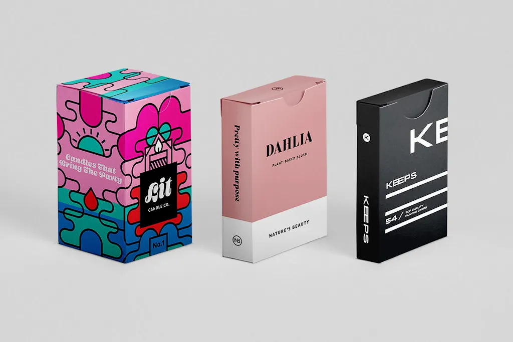 Three tuck boxes in different sizes and black, pink, green and blue color.