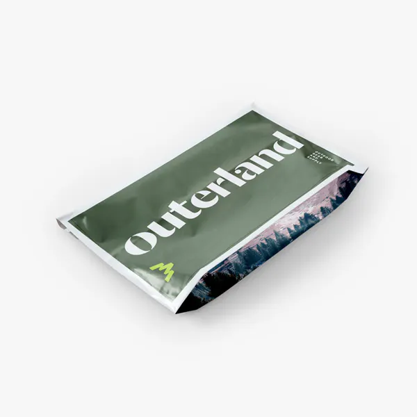 A poly mailer with a gusseted bottom printed with a dark green background and Outerland in white.